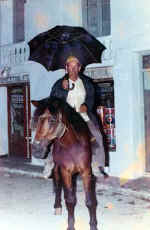 Lucio Haya Tello " El Mudo" a caballo y con paraguas.