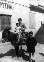 Nios de la familia Latorre montando a burro.